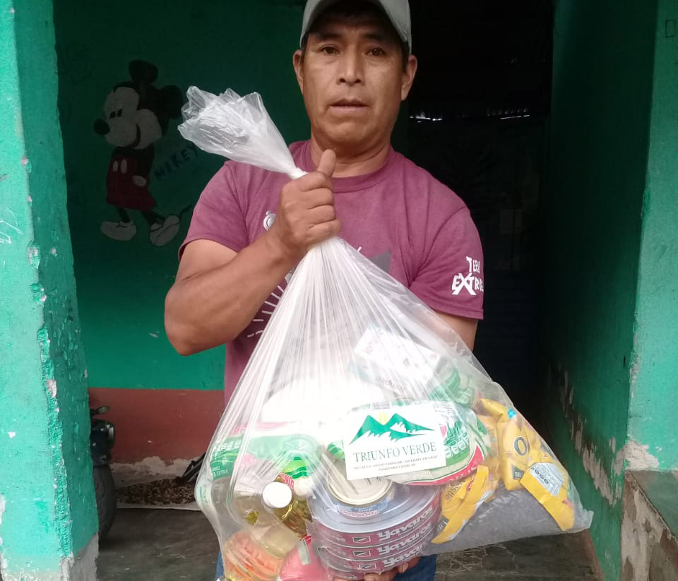 A farmer holding food supplies provided by the Triunfo Verde coffee cooperative in Mexico.