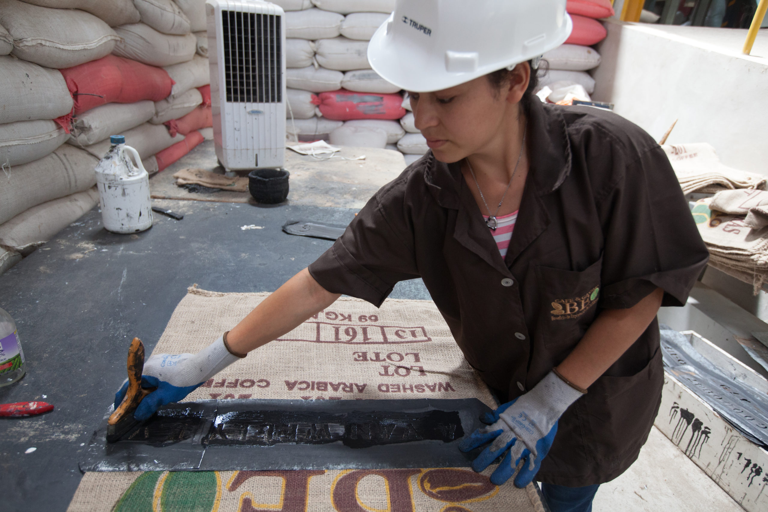 Ruth Noemí Badilla Carranza, labels coffee sacks with the names of contracts and clients at COAGRICSAL, Fairtrade-certified cooperative in La Entrada, Copán, Honduras.