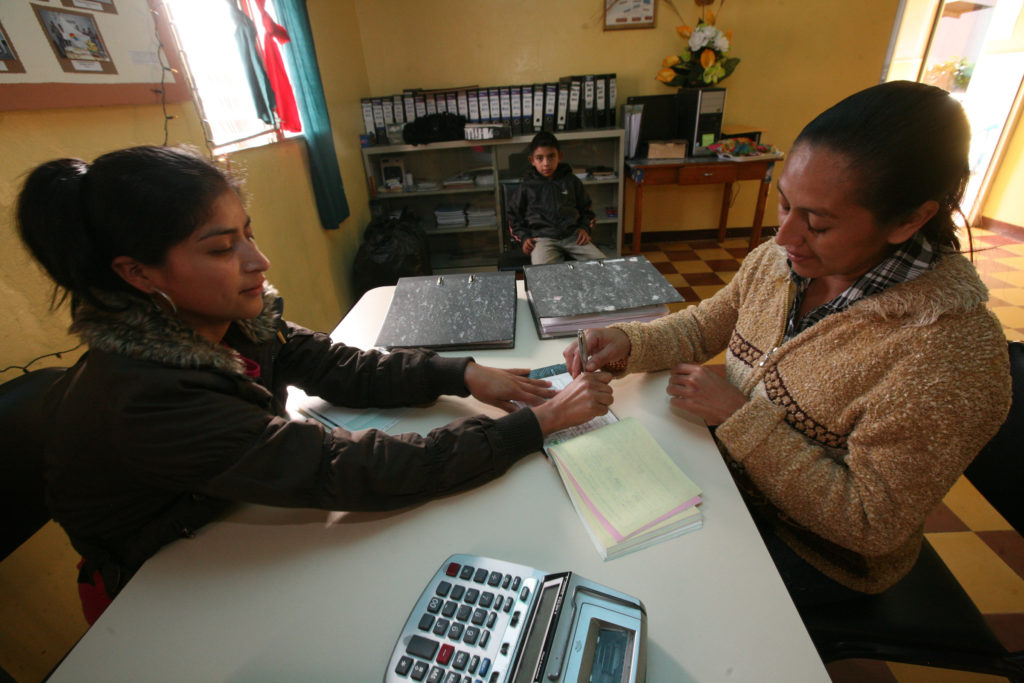 A cooperative employee documents a member's coffee and pays her for the sale.