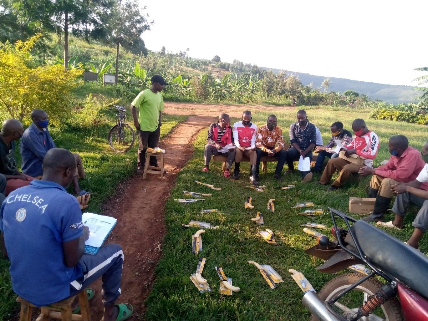 Intern Pierre Ndabazi of Cocahu, a coffee cooperative in Rwanda, trains coffee farmers on coffee pruning. Photo credit: Gladys Thitu/Root Capital